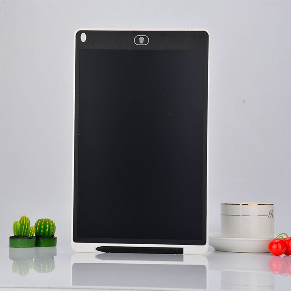 Black electronic writing pad on a white surface with decorative items.