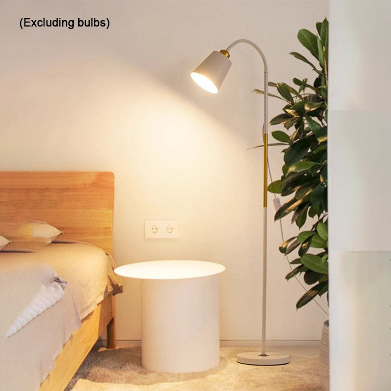 Modern bedroom setup with a bed, side table, and floor lamp.