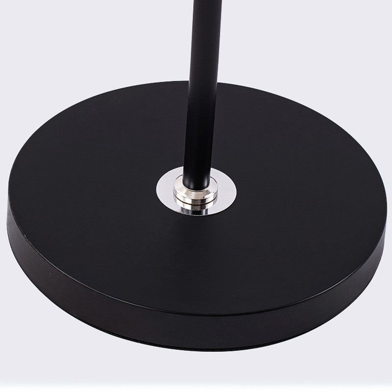Black round base with a central metallic fixture on a light gray background