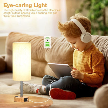 Child wearing headphones and using a tablet next to a small table lamp on a couch.