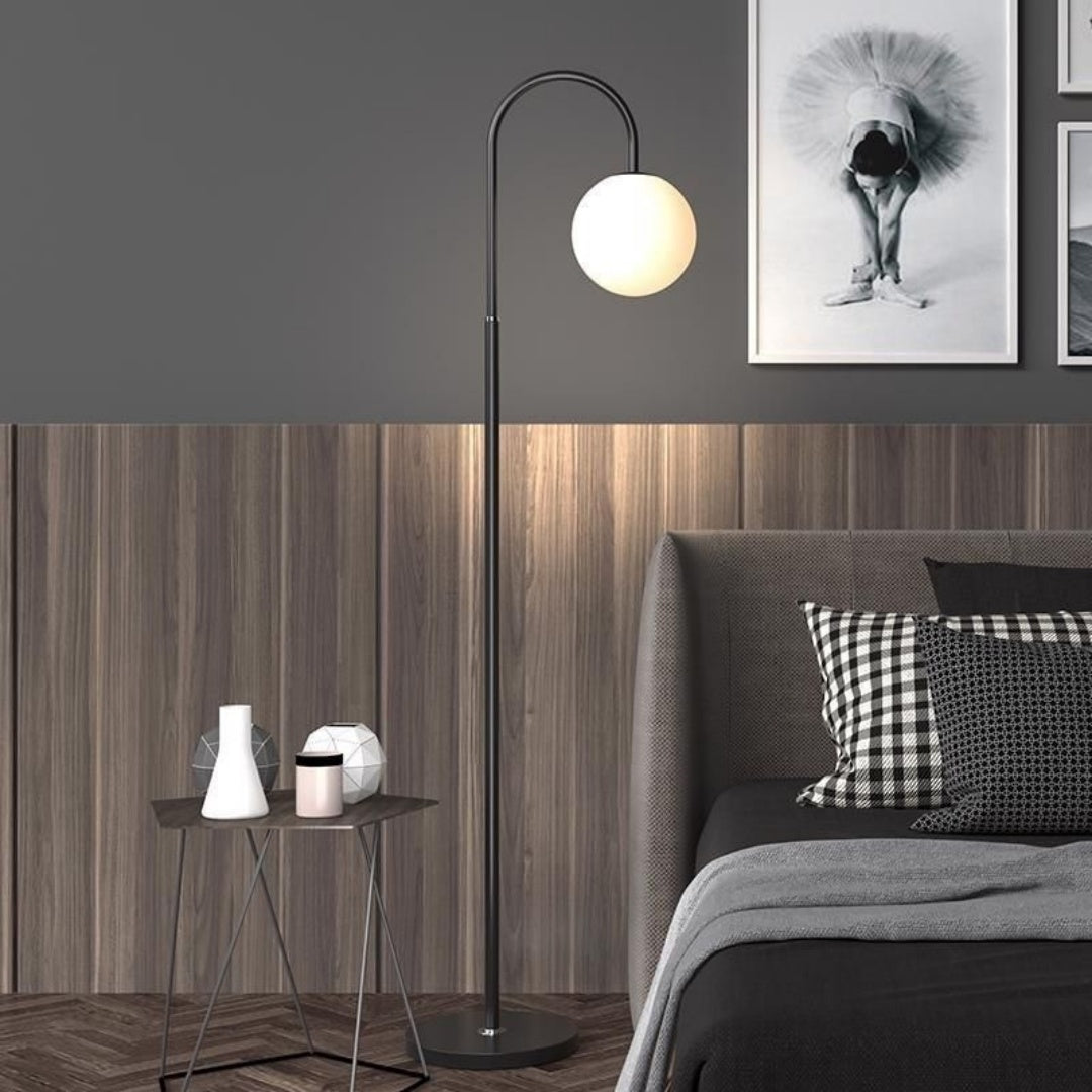Modern living room with a floor lamp, side table, and sofa with decorative pillows.
