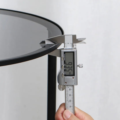 Digital caliper measuring a round metal object against a white background