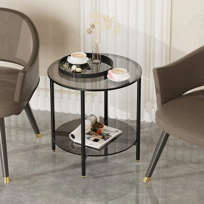 Round glass side table with black metal frame in a room setting with chairs and decor items.