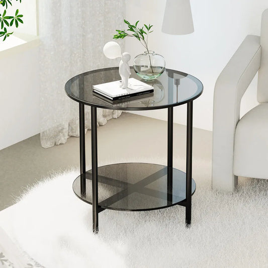 Round glass side table with black metal legs in a living room setting.