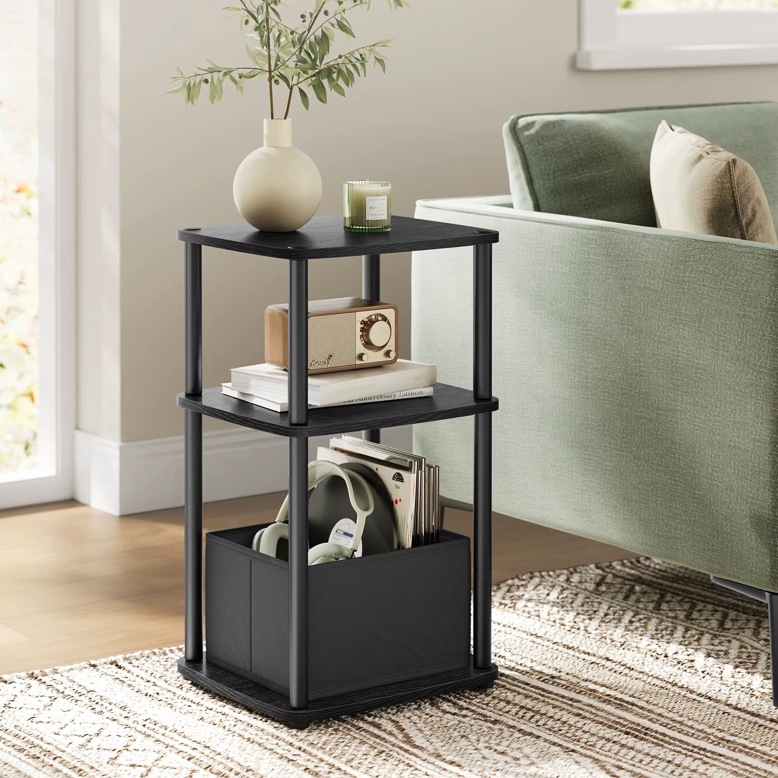 Black three-tier side table with decorative items in a living room setting.