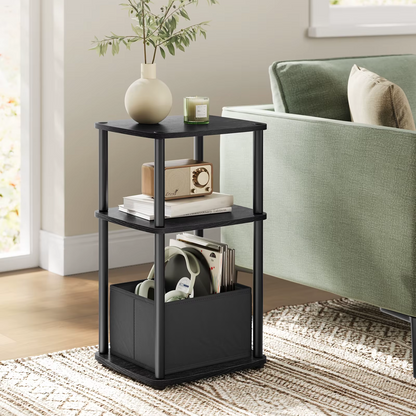 Black three-tier side table with decorative items in a living room setting.