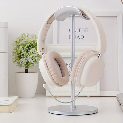 Beige headphones on a stand with a white background