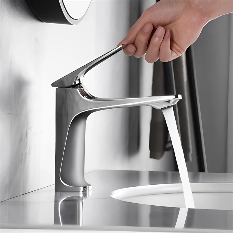 Chrome faucet with water flowing into a sink in a bathroom setting