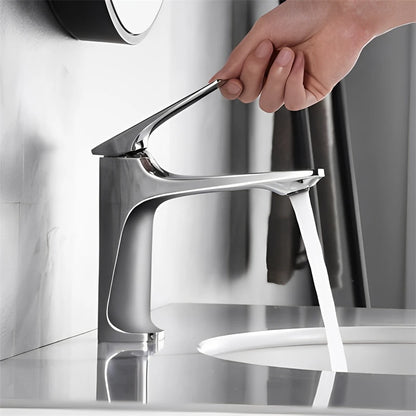 Chrome faucet with water flowing into a sink in a bathroom setting