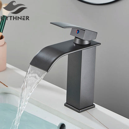 Black faucet with water flowing into a sink, branded 'WYTHNER'.