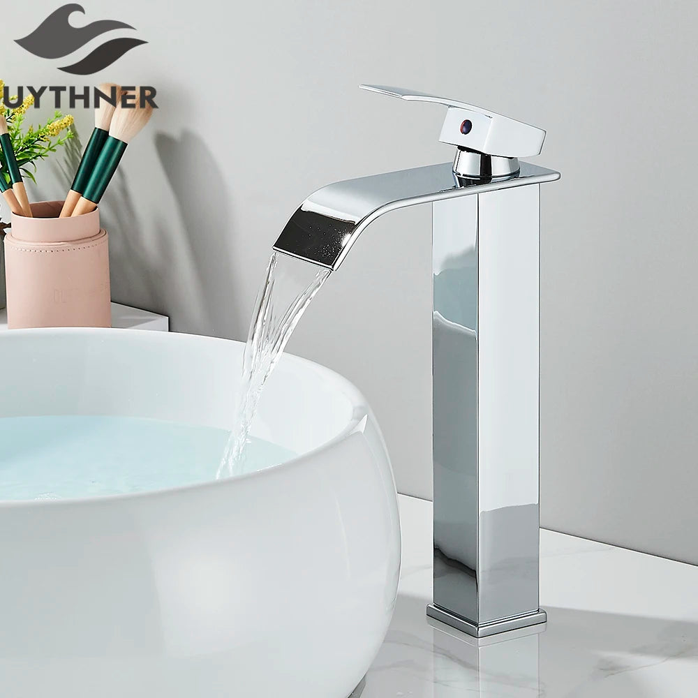 Chrome waterfall faucet on a sink with 'GUYTHNER' branding in the background.