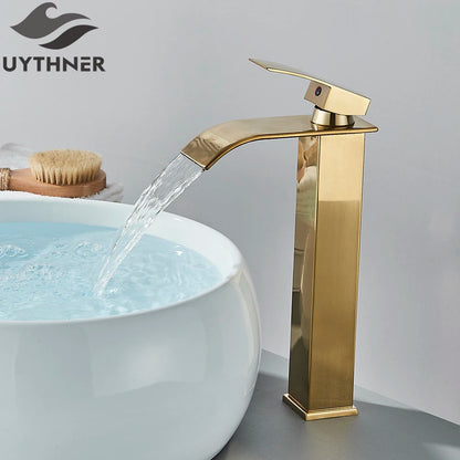 Gold faucet pouring water into a white sink with Uythner branding.