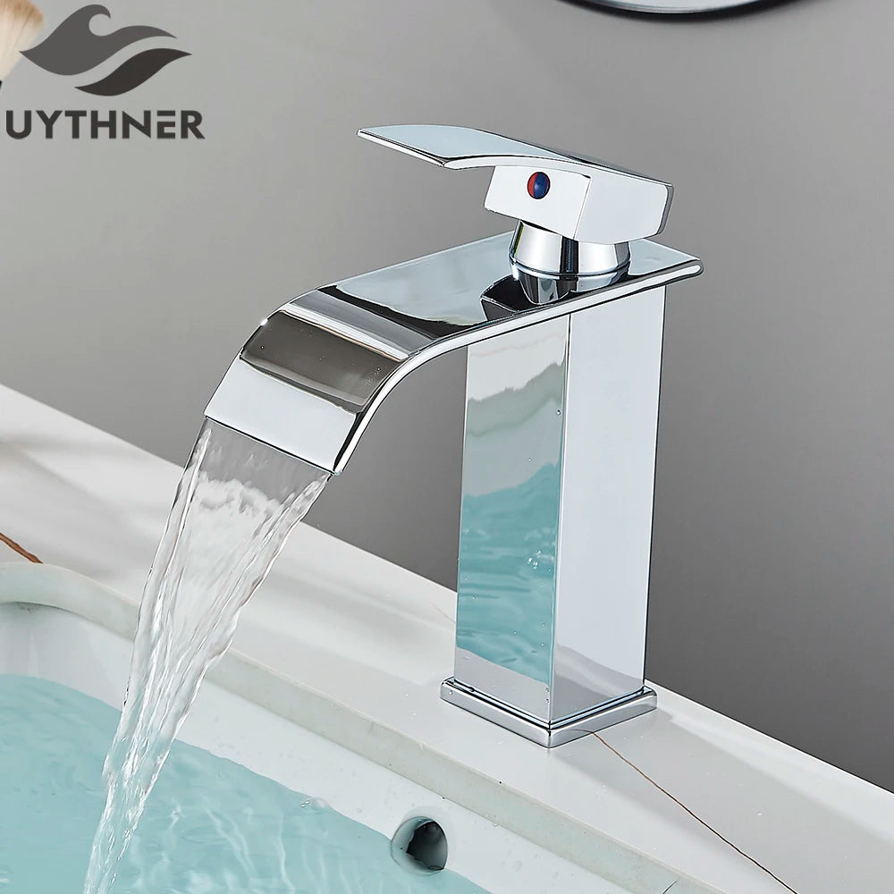 Chrome waterfall faucet with water flowing into a bathtub, branded 'UYTHNER'.