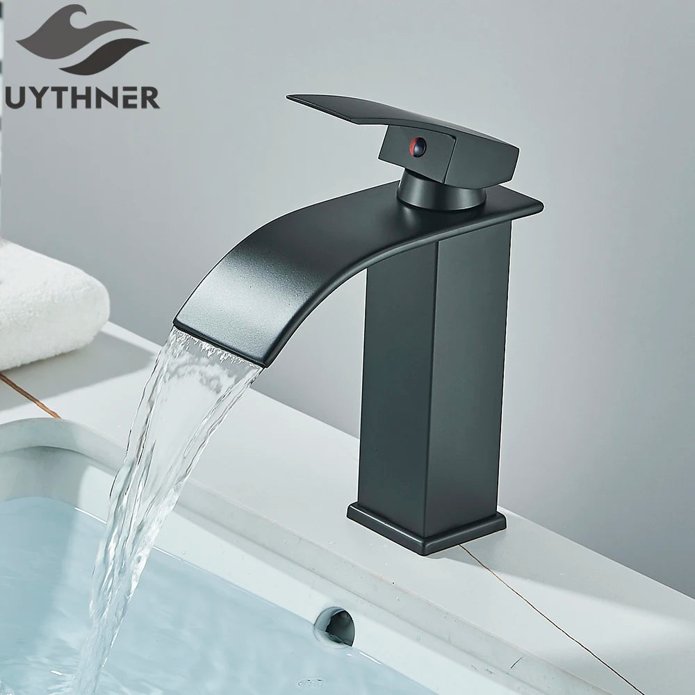 Black faucet with water flowing into a sink, branded 'UYTHNER'.