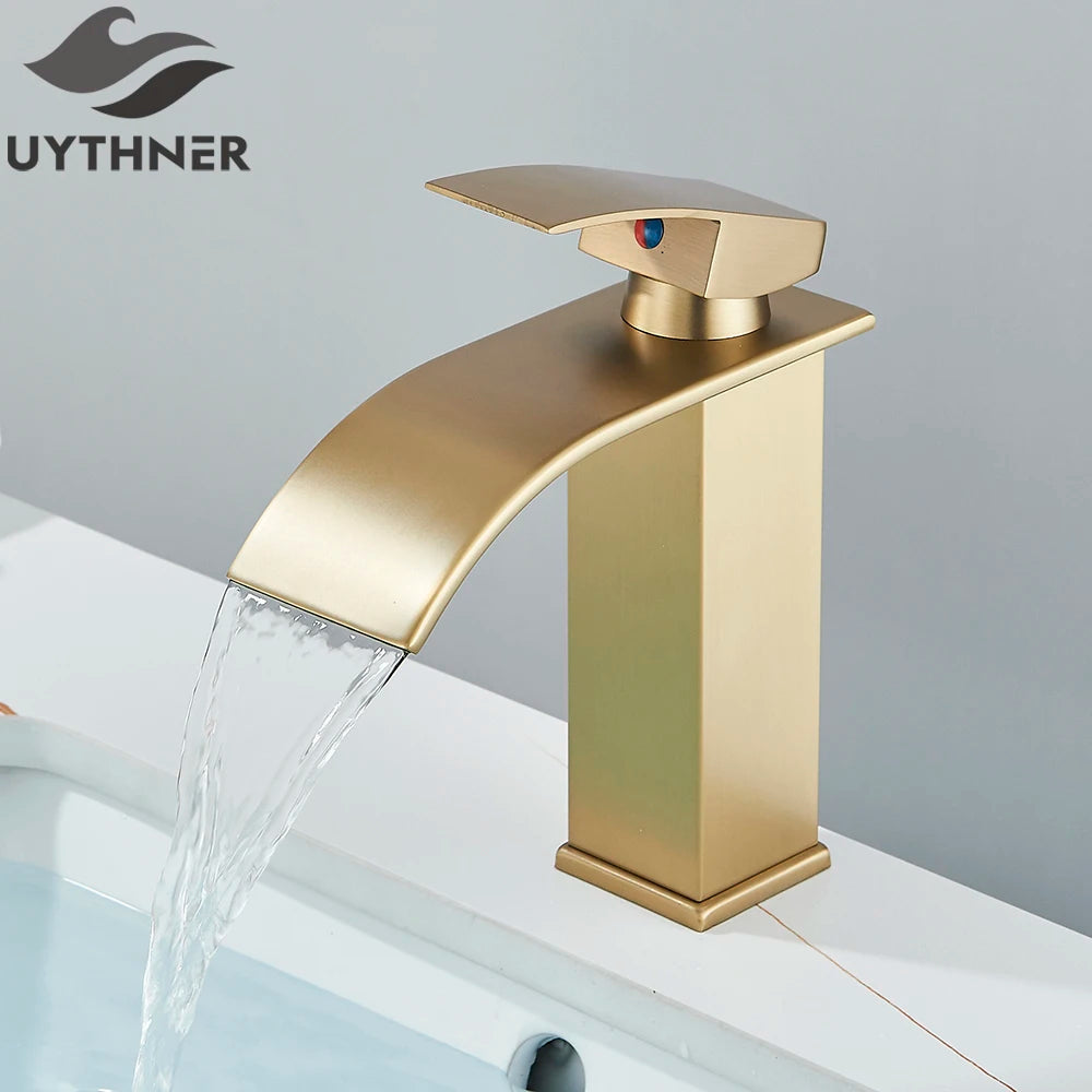 Gold faucet with water flowing, branded 'UYTHNER', on a gray background