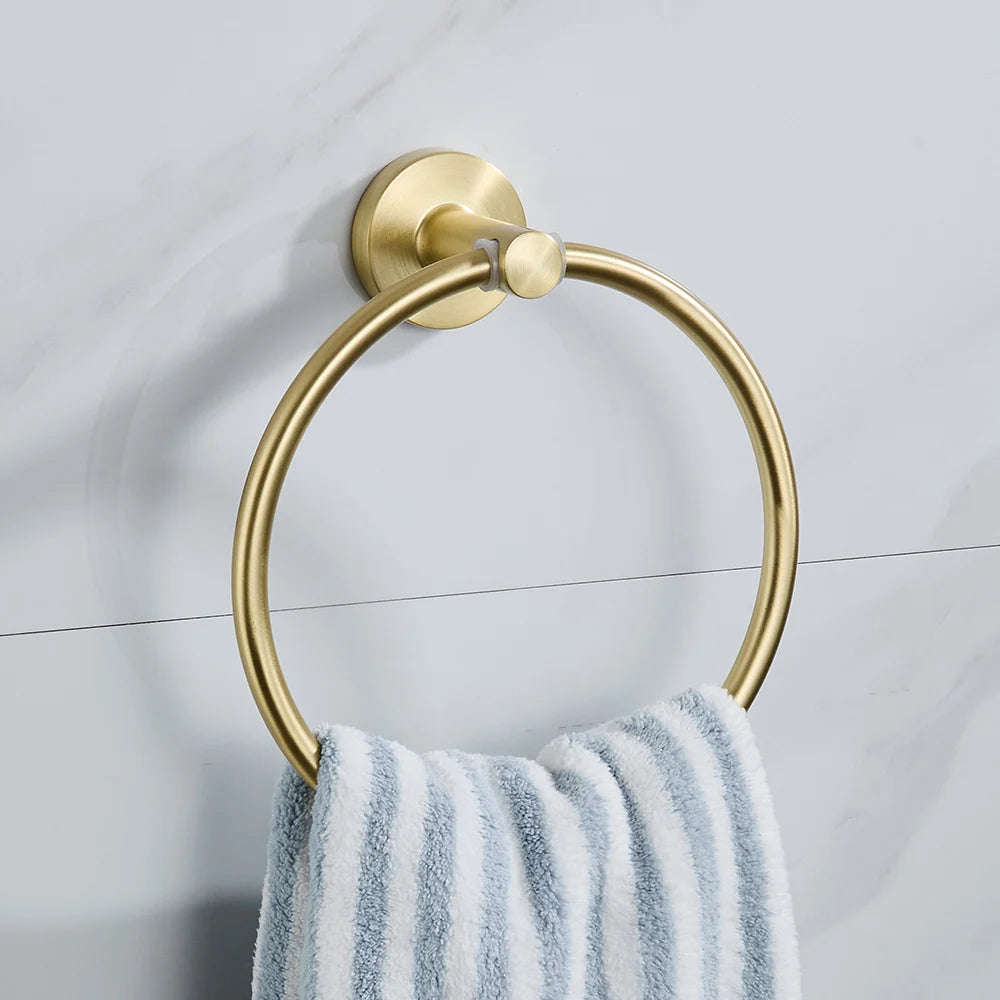 Gold towel ring with a striped towel on a light gray wall