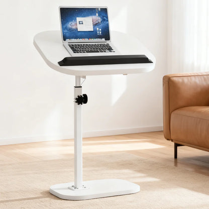White adjustable laptop stand with a laptop on top in a room with a brown couch.