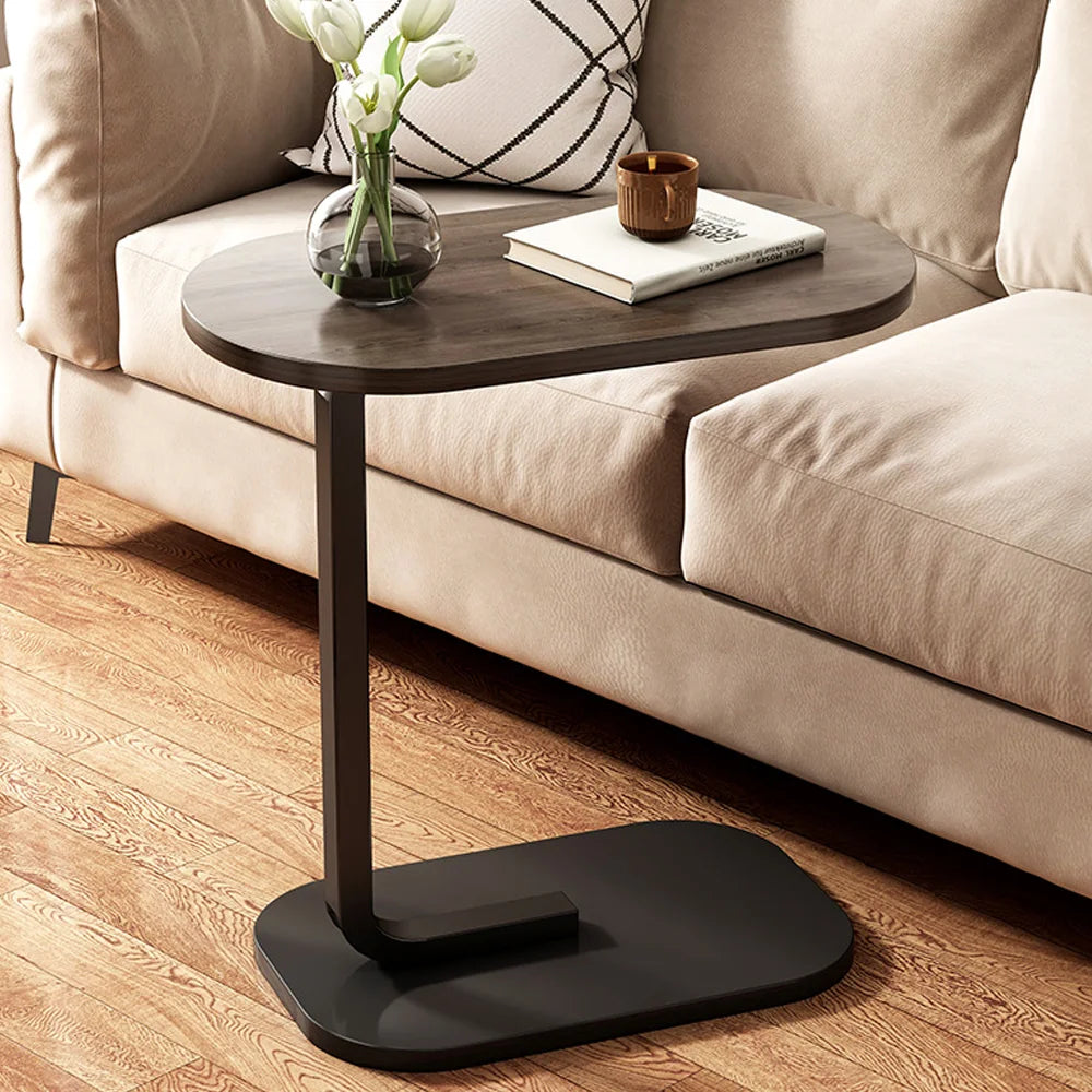 Small wooden side table with black base next to a beige sofa.