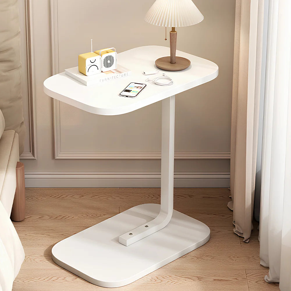 White adjustable table in a room with a lamp and small radio on top