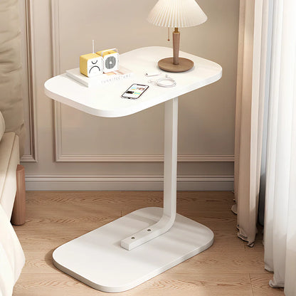 White adjustable table in a room with a lamp and small radio on top