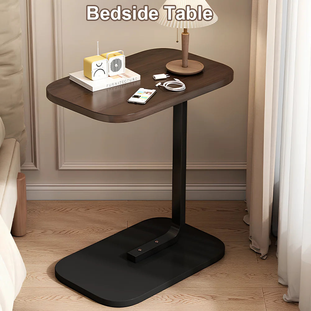 Bedside table with various items on a wooden floor in a bedroom setting