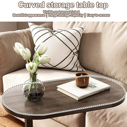 Curved storage table top on a sofa with a vase of flowers and a book.