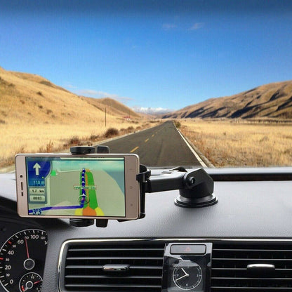 Phone with GPS app on a car dashboard with a scenic road in the background