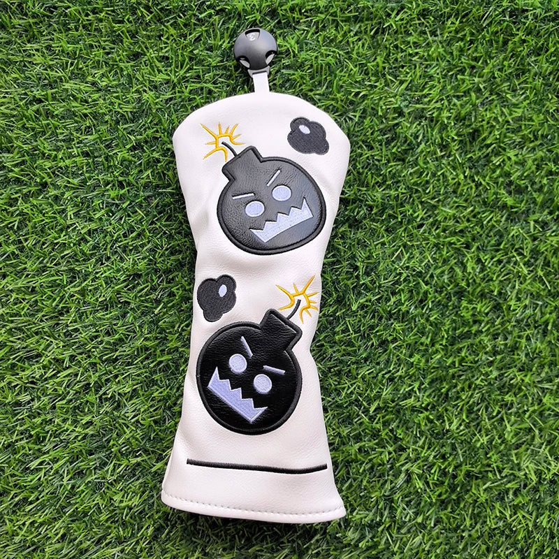 Golf club head cover with bomb design on a grass background