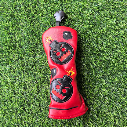 Red golf club head cover with black designs on a green grass background
