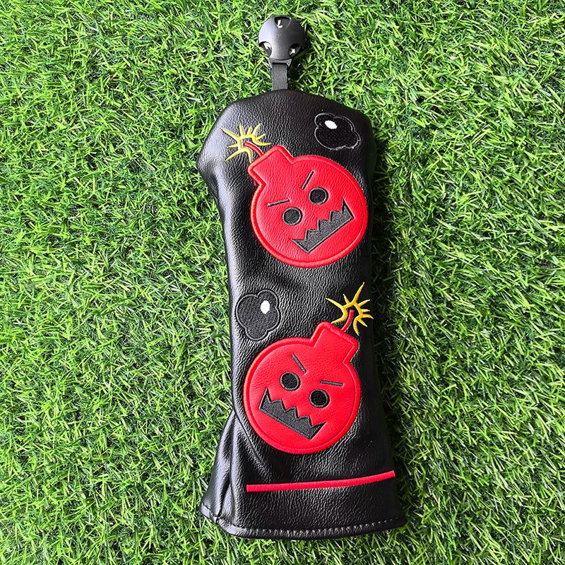 Black golf club head cover with red bomb design on a grass background