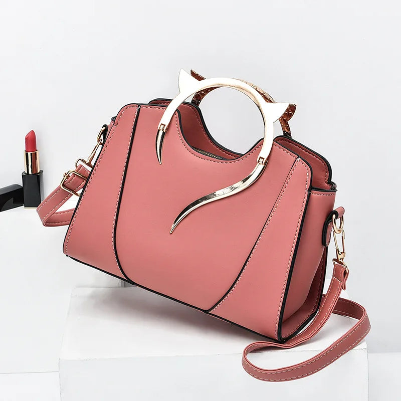 Pink handbag with gold accents on a white background