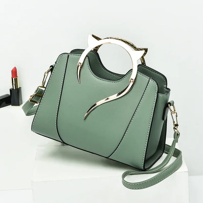 Green handbag with unique handle design on a white background