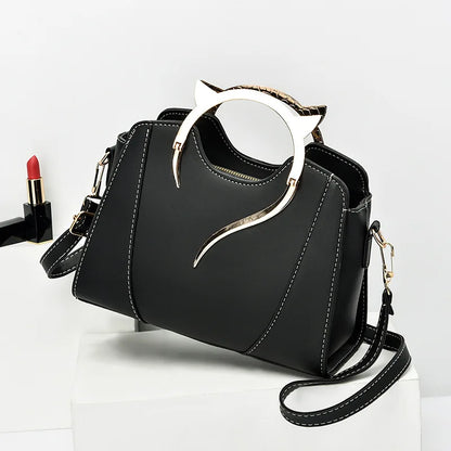Black handbag with decorative handle on a white background