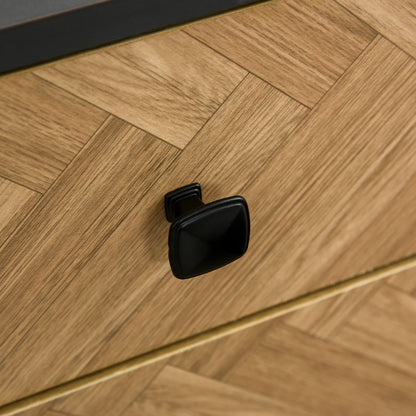 Close-up of a black cabinet handle on a wooden surface
