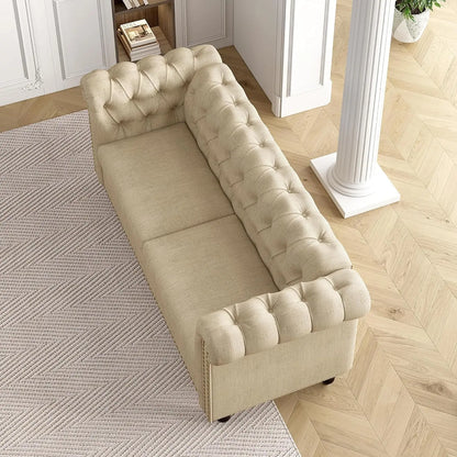 Beige tufted sofa in a room with wooden flooring and a rug.