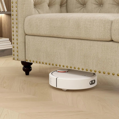 Robotic vacuum cleaner on a wooden floor next to a beige sofa.