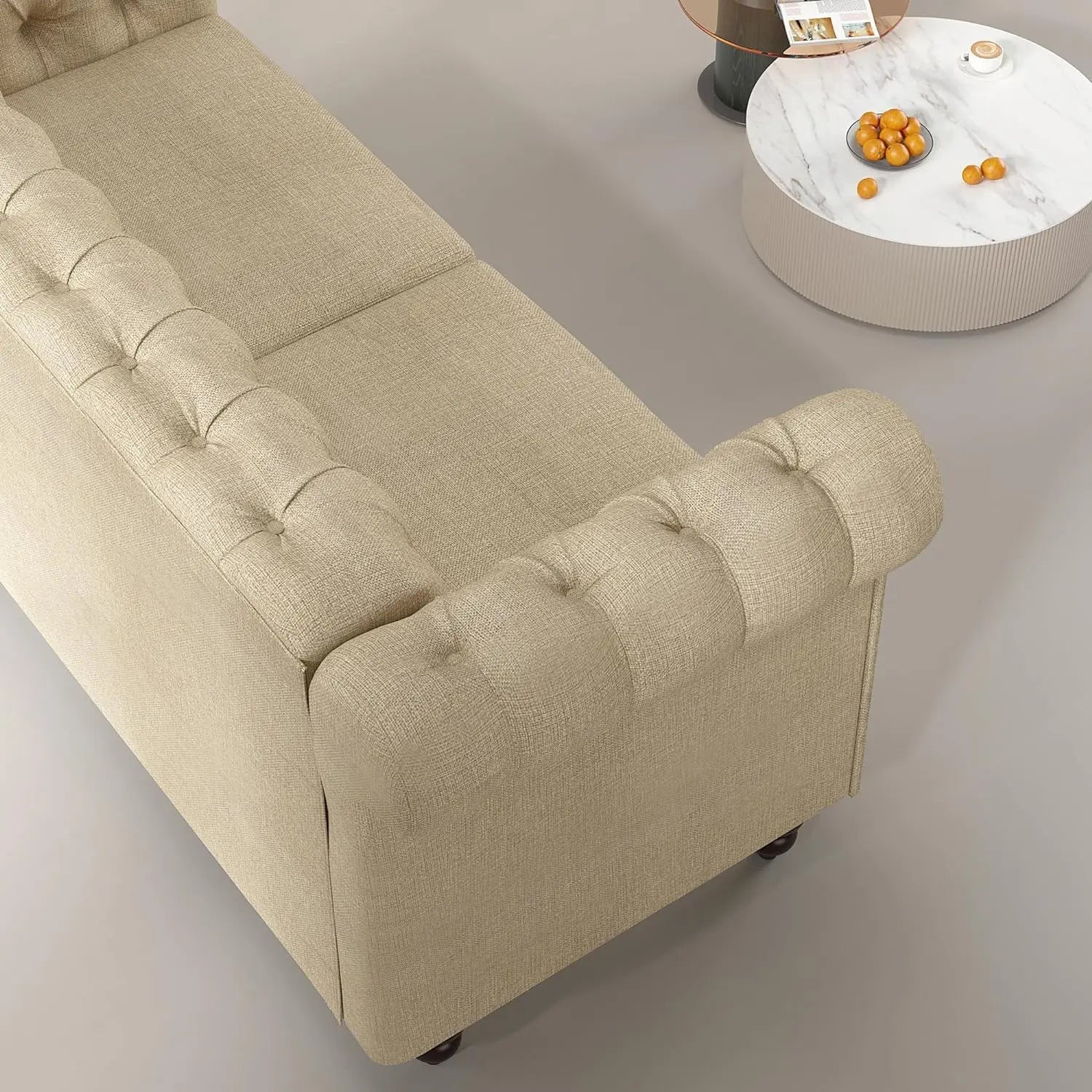 Beige sofa with tufted backrest in a minimalistic room.