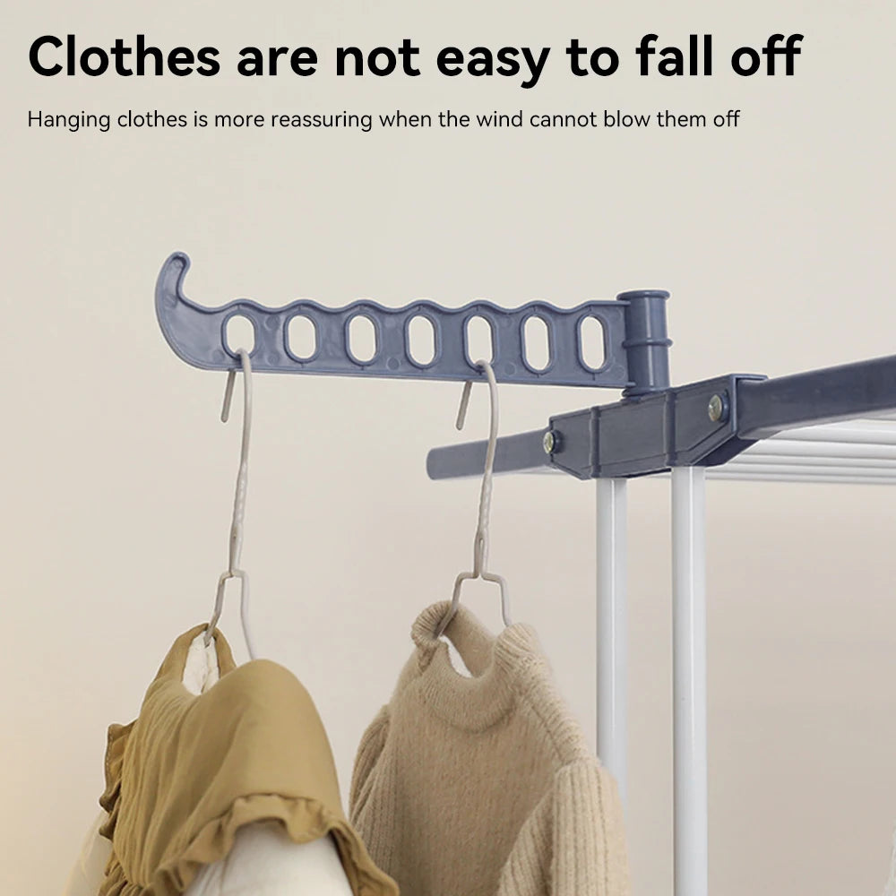 Clothes drying rack with hanging clothes on a plain background