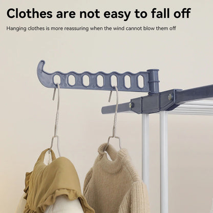 Clothes drying rack with hanging clothes on a plain background
