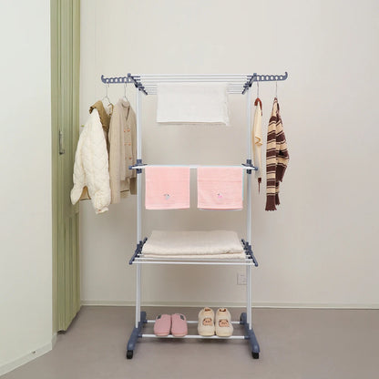 Portable clothing rack with clothes and shoes in a room.