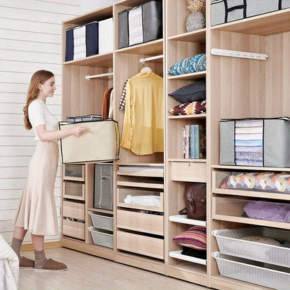 Woman organizing a wooden wardrobe with shelves and storage bins.
