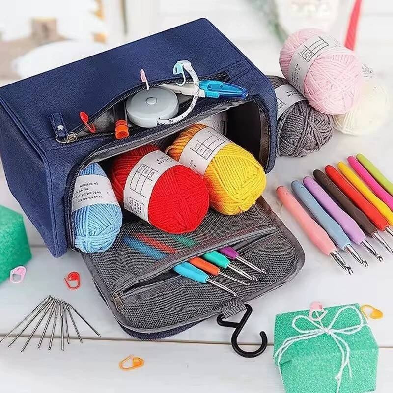 Open blue and gray pouch containing yarn and crochet tools on a white surface.