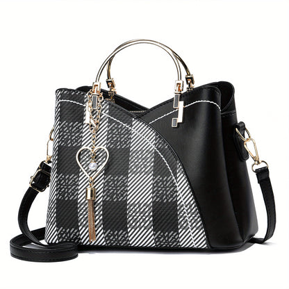Black and white plaid handbag with gold accents on a white background