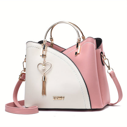 Pink and white handbag with a heart-shaped charm on a white background