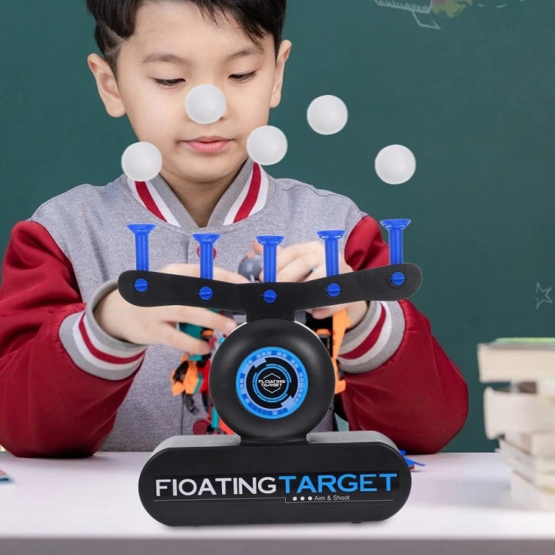 Child playing with a floating target toy in front of a chalkboard