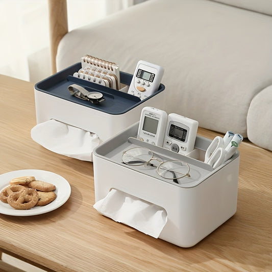White and blue storage box on a wooden table with various items including glasses, remote controls, and cookies.