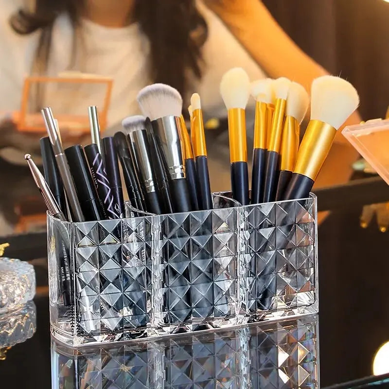 Set of makeup brushes in a clear diamond-patterned holder with a blurred background