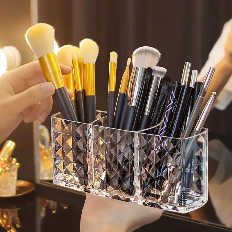 Collection of makeup brushes in a clear holder with a blurred background