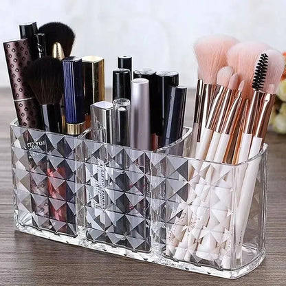 Clear diamond-patterned makeup organizer with brushes and bottles on a wooden surface.