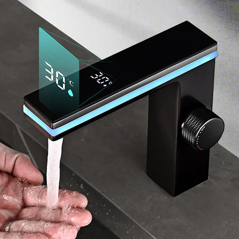 Modern black faucet with digital temperature display dispensing water into a hand.